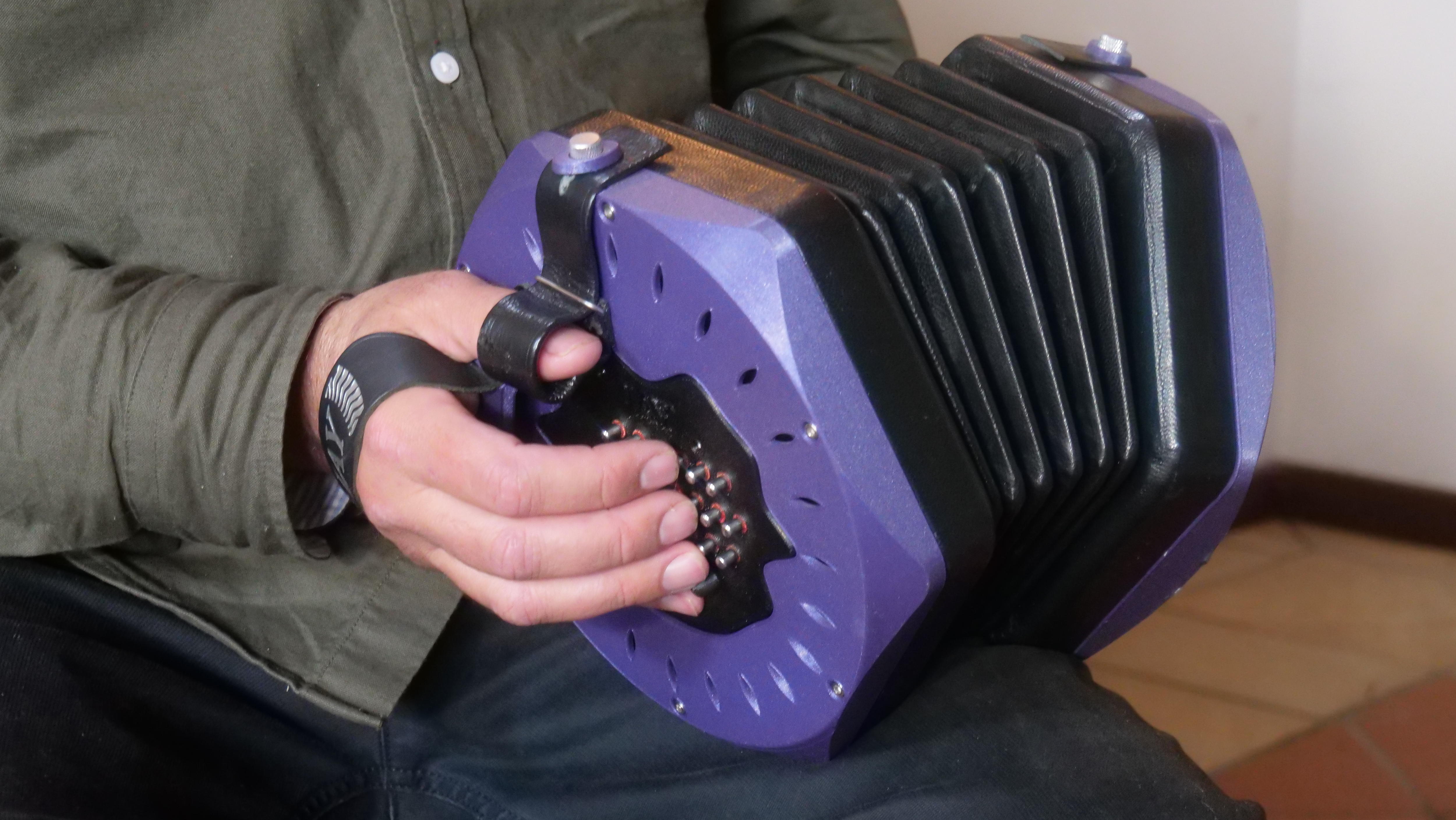 A close of hand holding a concertina