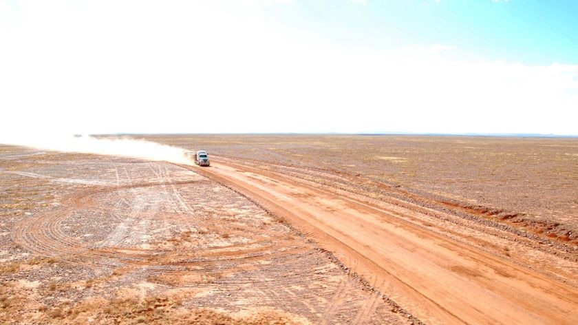 A truck makes its way along a dirt road