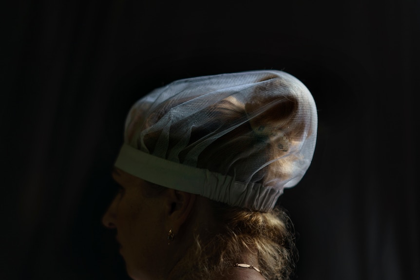 A woman's hair tied in a bun inside a hair net