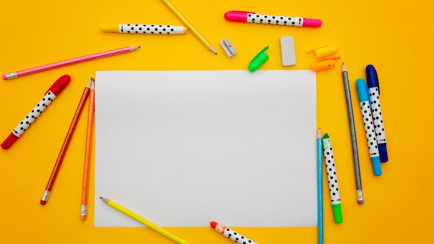paper and pens on a yellow background
