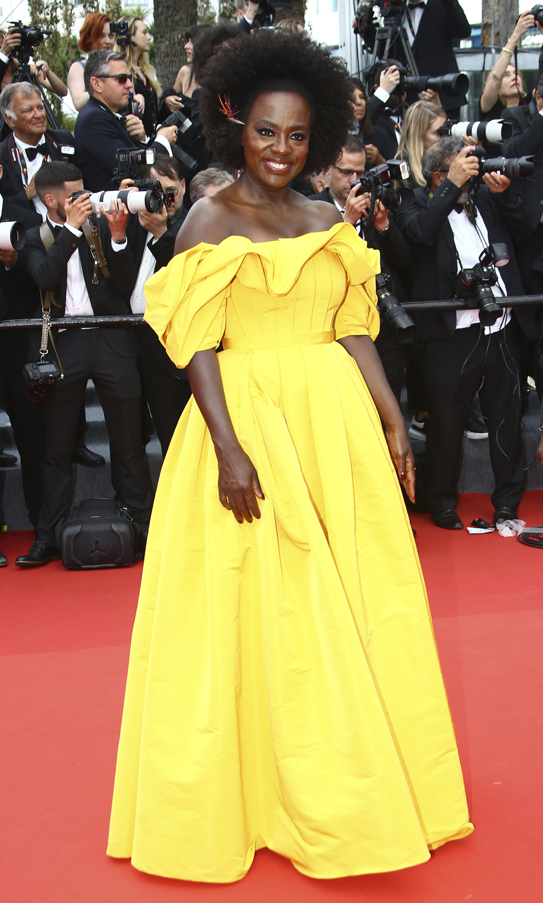 Viola Davis wearing a long yellow gown with ruffled sleeves and a full skirt. 