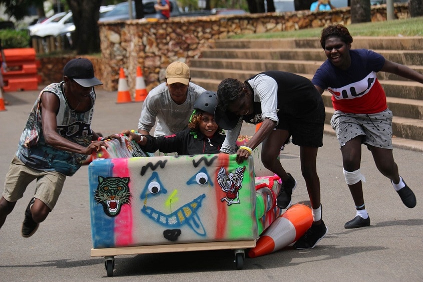 A group of boys push a couch in Darwin's annual couch surfing race