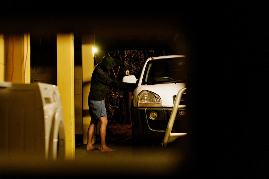 Break in photo of man using crowbar on window