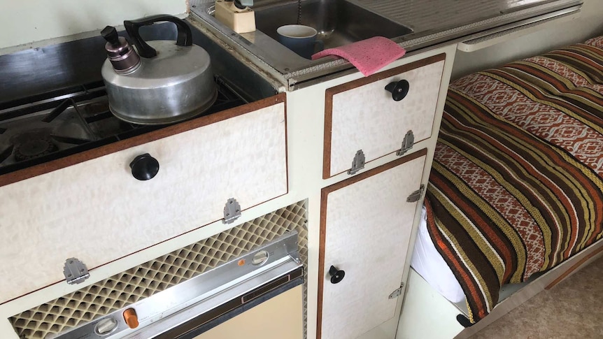 Shot of the fridge inside Claude Harris' van with vents around it