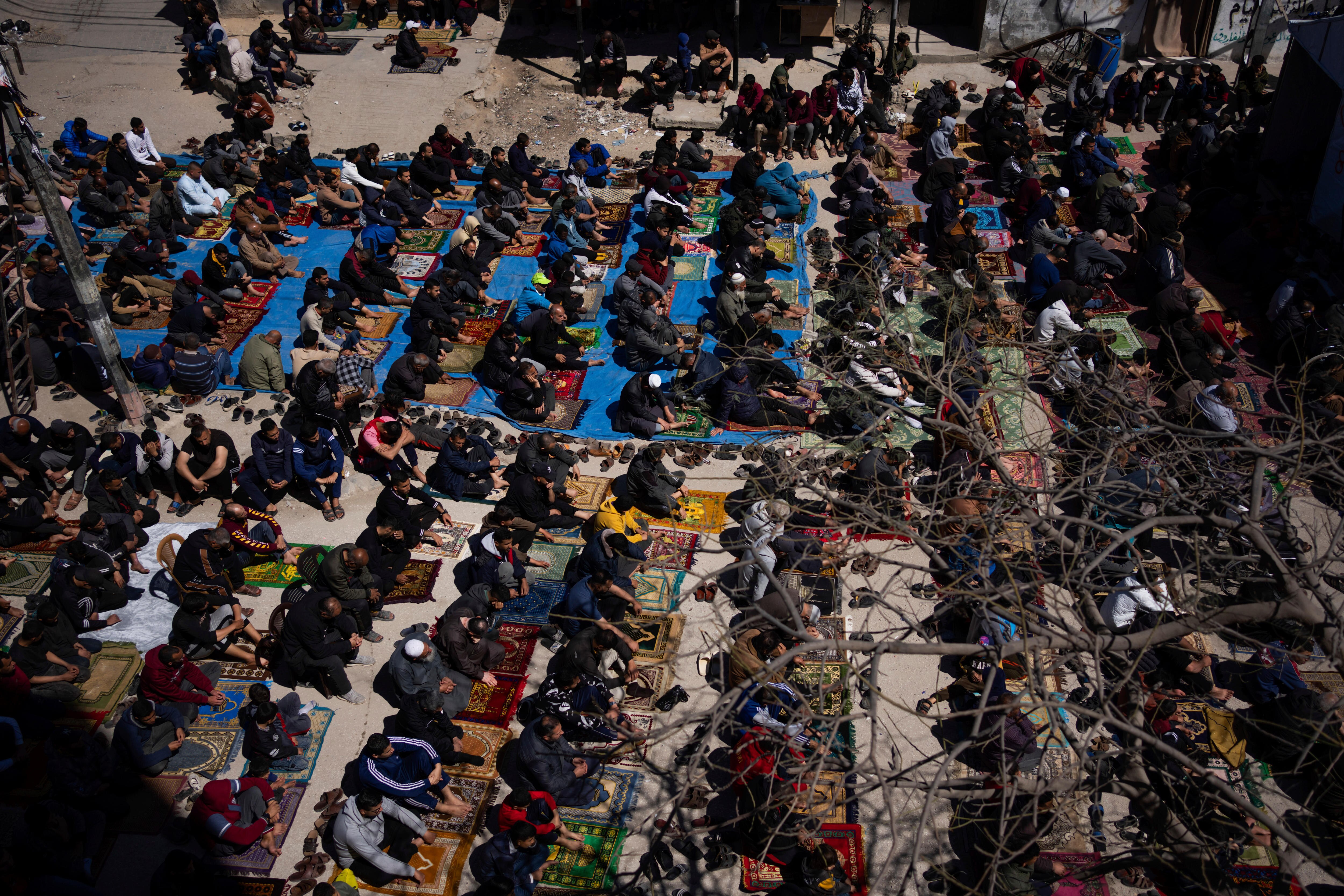 Paelstinians perform Friday prayers near the ruins of a destroyed mosque in Rafah
