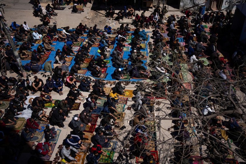 Paelstinians perform Friday prayers near the ruins of a destroyed mosque in Rafah