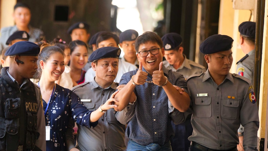 Handcuffed Reuters journalist Wa Lone gives a thumbs up in front of the court