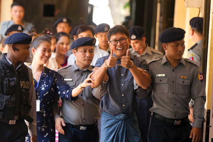 Handcuffed Reuters journalist Wa Lone gives a thumbs up in front of the court