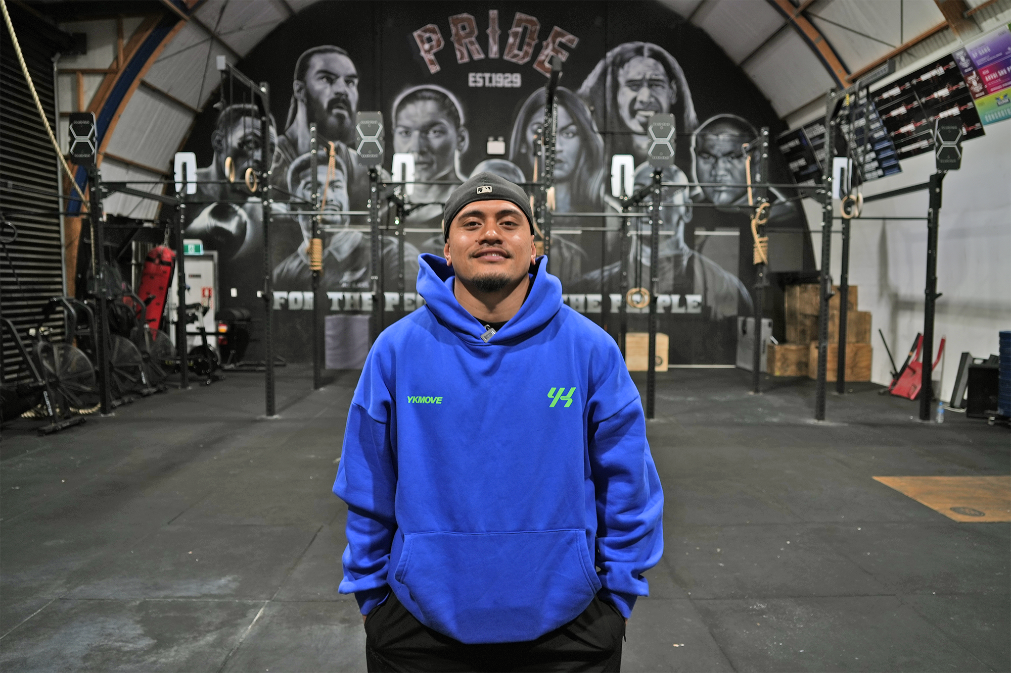 A photo of Johnnie wearing a blue hoodie and black hat backwards.