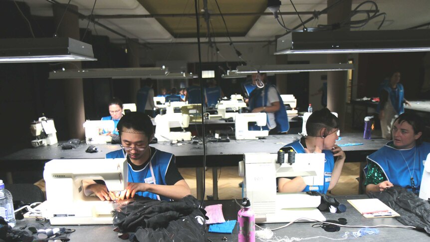 Workers in a workshop making onesies.