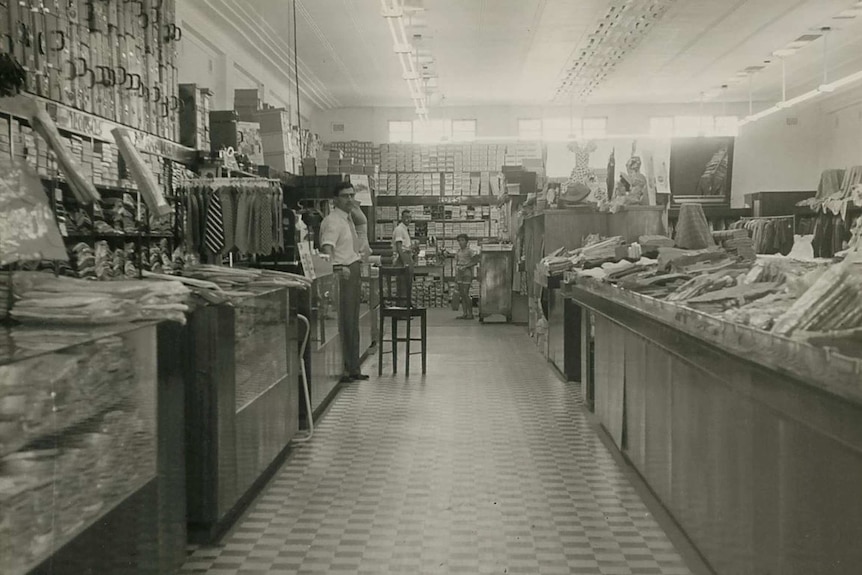 A black and white photo showing a clothing store men's department in 1955.