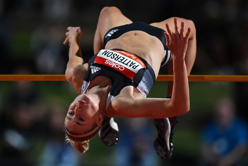 A female high jumper clears the bar at the Sydney Track Classic.