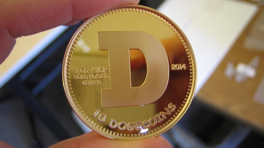 A photo of a gold 'Dogecoin' between two fingers