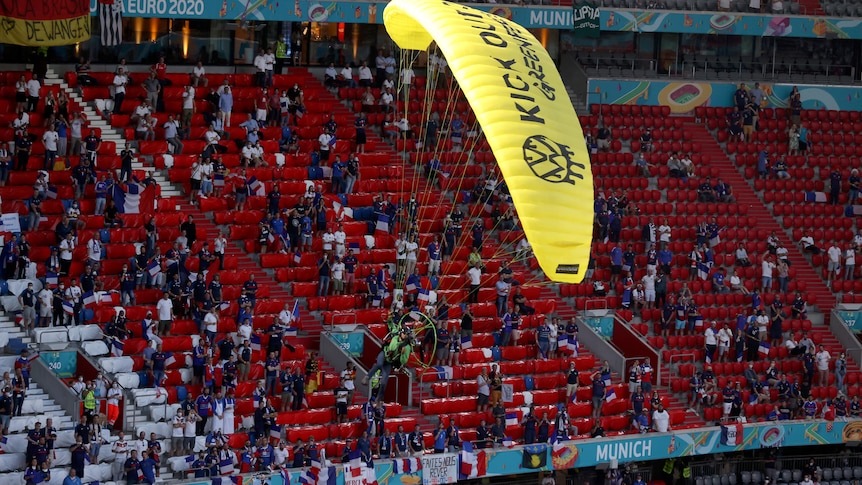 Greenpeace protester paraglides into Euros stadium, injures two men while landing