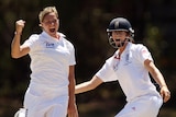 Katherine Brunt celebrates a wicket by raising her first in the air, her teammate is next to her smiling.