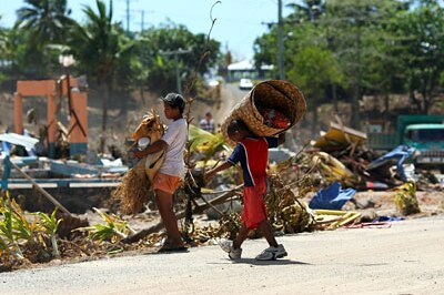 Samoan children carry salvaged bedding (Getty Images)