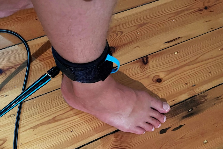 A foot with a blue and black legrope attached to the ankle