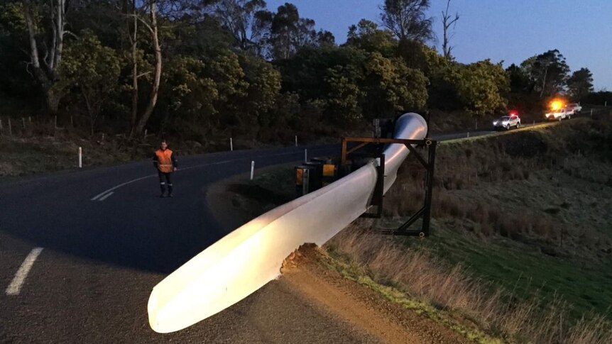 A wind turbine wing left on the road after a truck rollover.