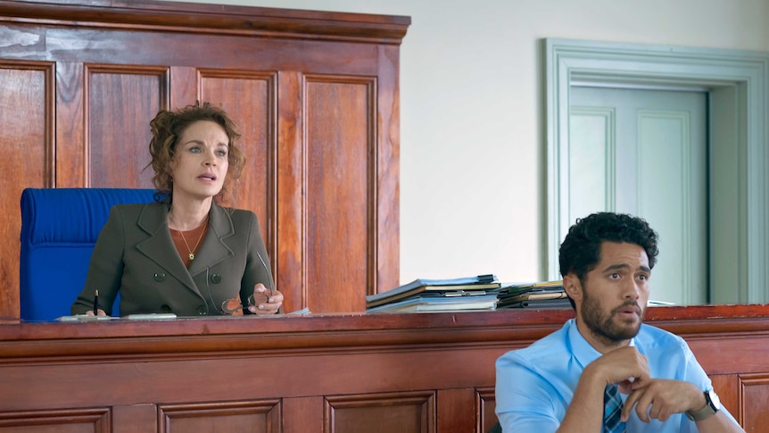 Sigrid Thornton and Alex Tarrant sit behind benches in court