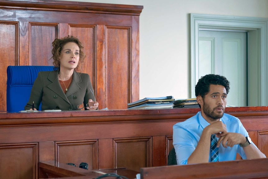 Sigrid Thornton and Alex Tarrant sit behind benches in court