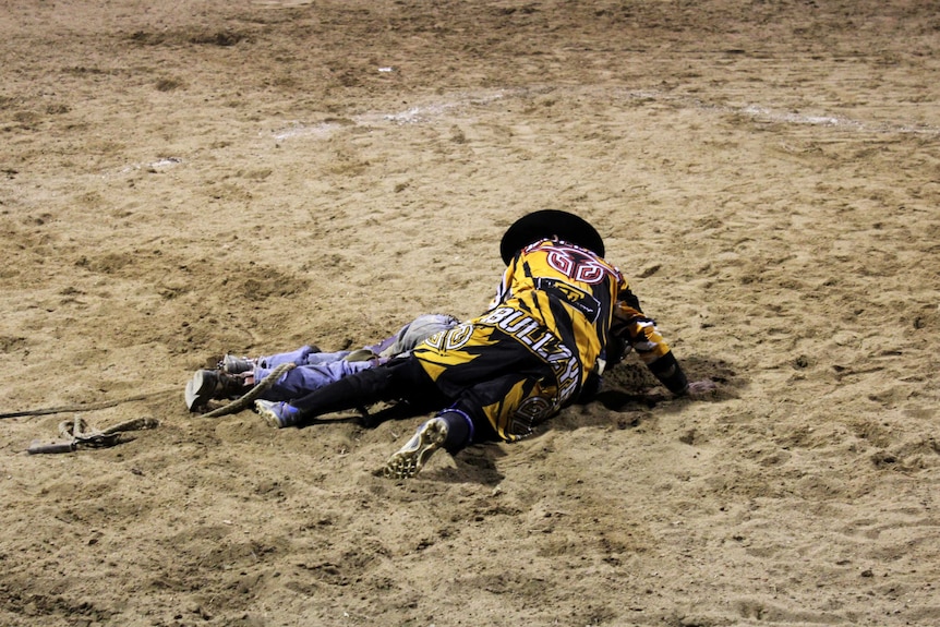 A protection athlete crouches over Jay Borghero