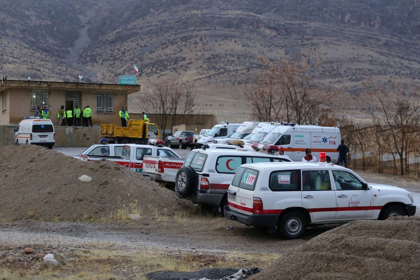 Ambulances and vehicles are seen in a mountainous area.