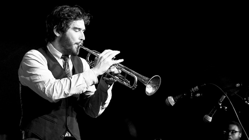 A black and white photo of a man playing a trumpet