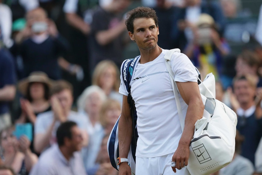 Rafael Nadal trudges off Wimbledon's centre court with a disappointed expression on his face.