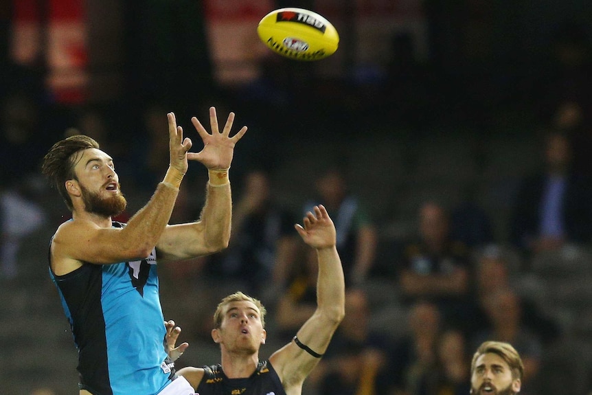Port Adelaide's Charlie Dixon marks against Richmond's David Astbury at Docklands on March 10, 2016.