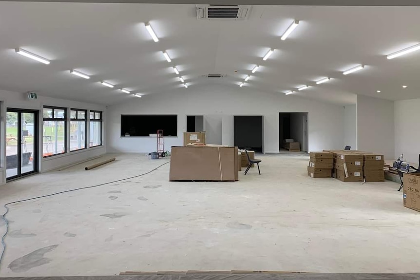 A large white-walled room with a pitched room and large windows.