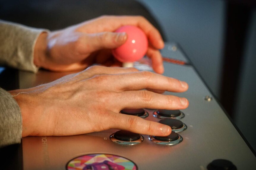 A close-up of Ian Campbell's hands as he plays Street Fighter V.