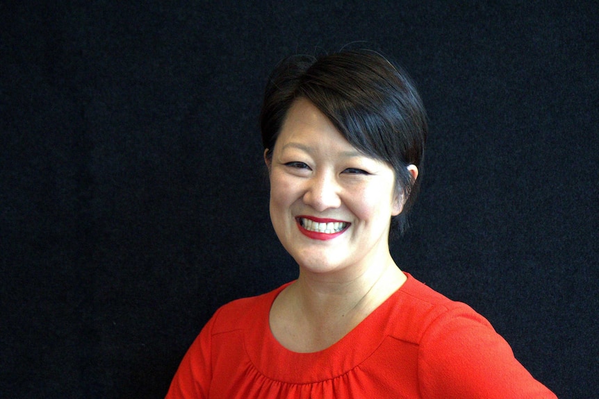 A headshot of Jean Lee in a red shirt