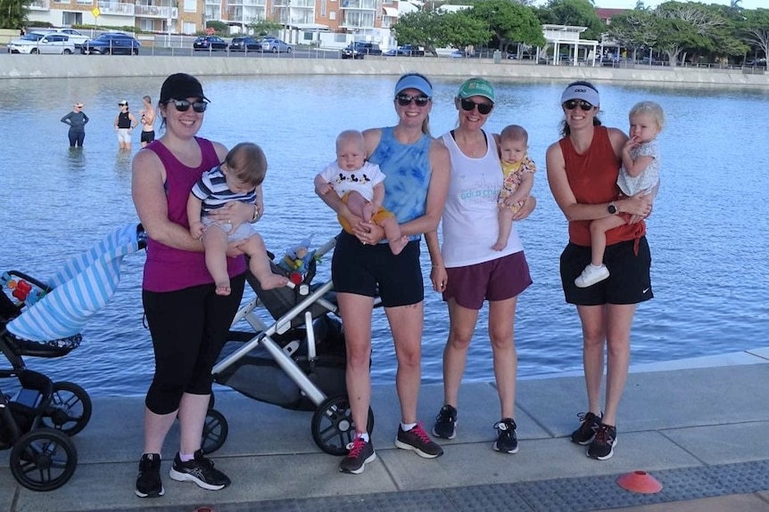 Four mothers hold babies in parkrun.