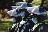 Three unidentifiable Victoria Police officers wearing face masks.