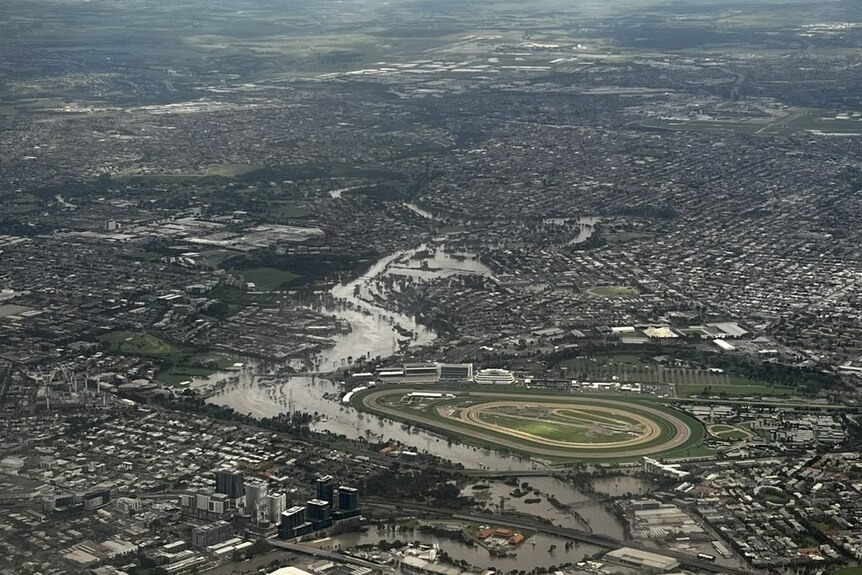 Aerial shot of a flooded community, while a racecourse remains dry. 