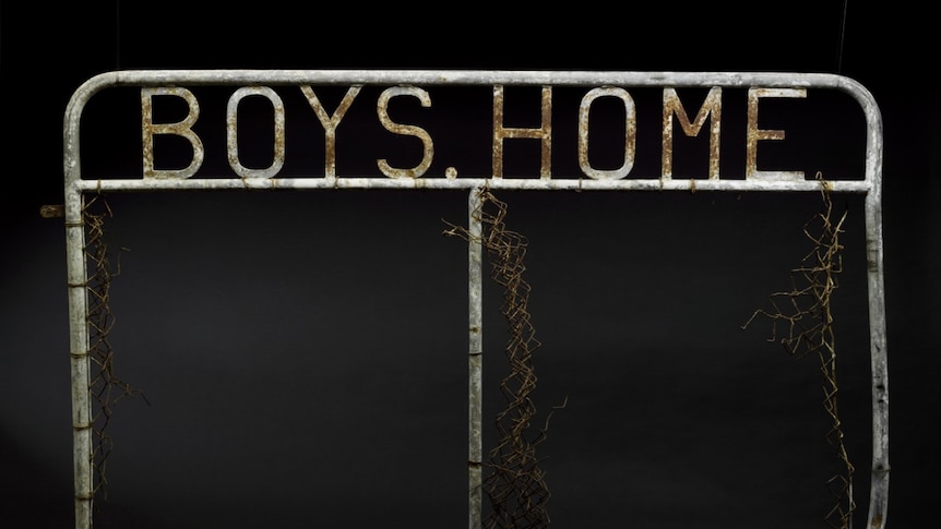 A metal gate with the words 'boys home' welded to the top.