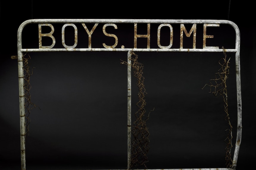 A metal gate with the words 'boys home' welded to the top.