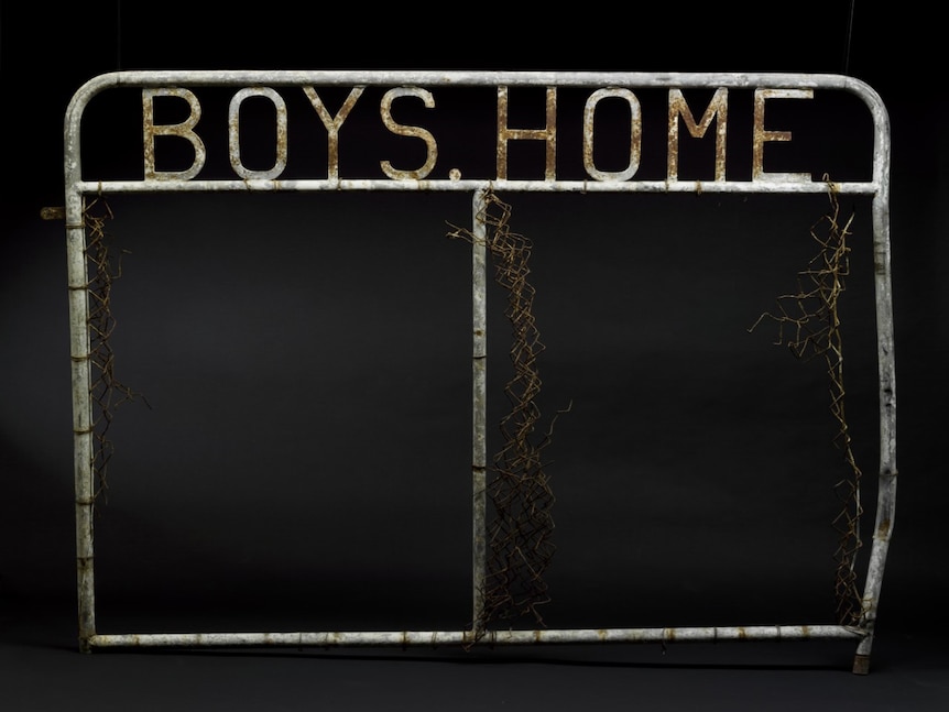 A metal gate with the words 'boys home' welded to the top.