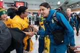 a female soccer player high fives a young fan at sydney airport