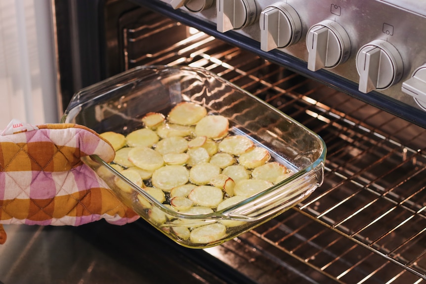 Heidi Sze puts a tray with sliced potatoes in the oven to prepare the base of her frittata.