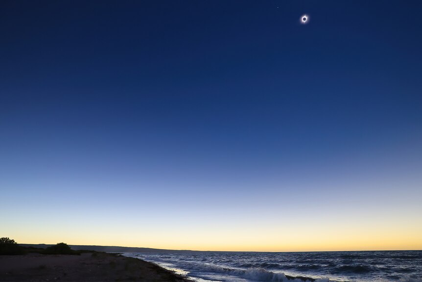 An isolated beach showcasing the solar eclipse