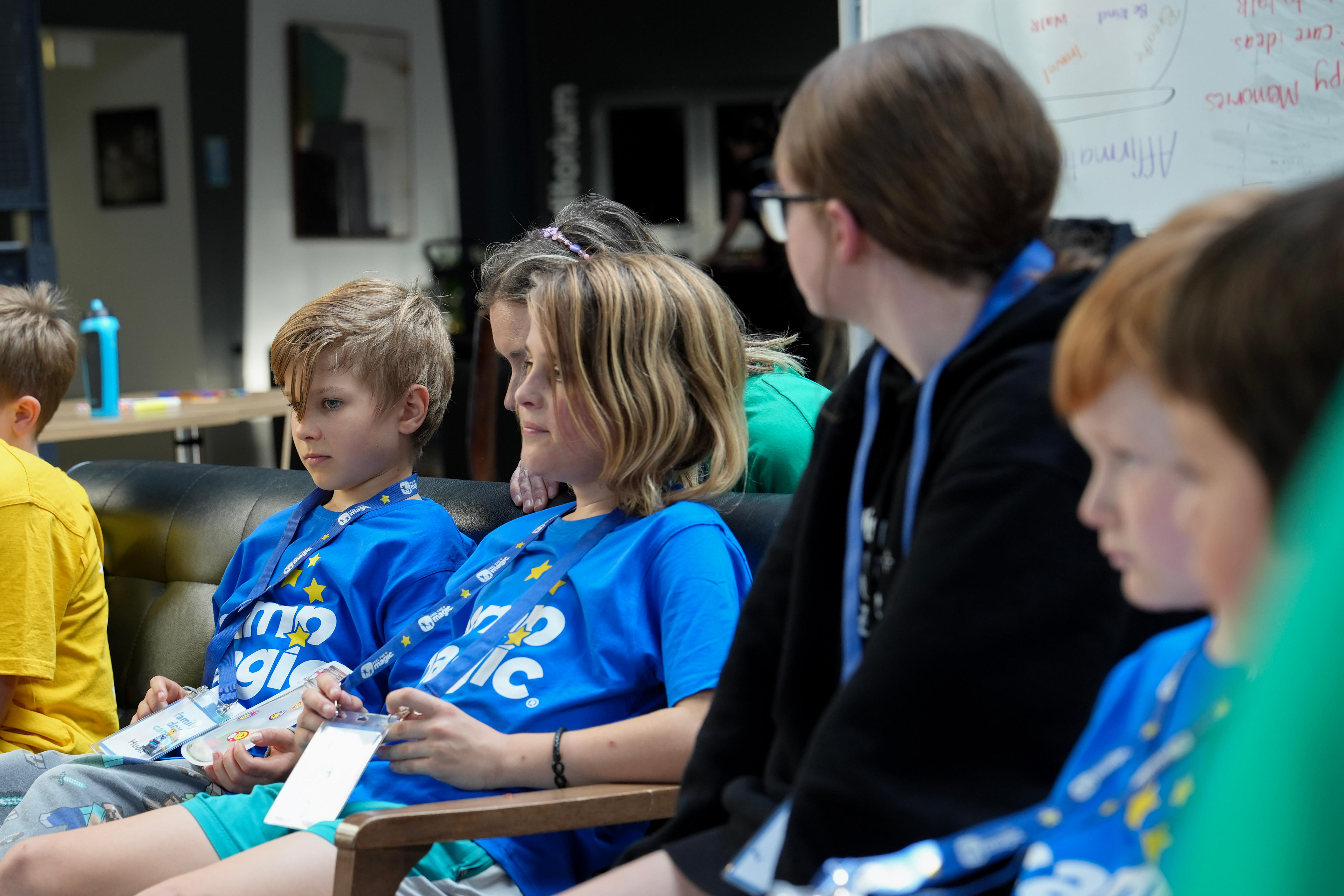 Two young children in blue shirts sit down