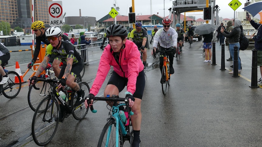 Bike riders in a group on a public road in a city.