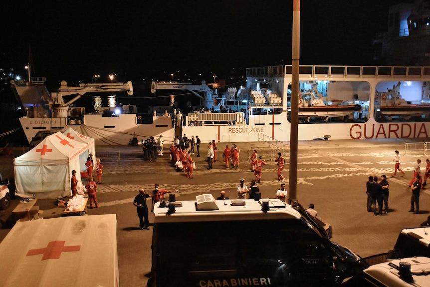 The pot and rescue workers are seen awaiting migrants at night.