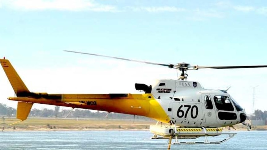 A firefighting helicopter filling up with water at Champion Lakes