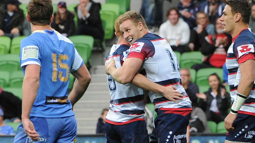 Try time ... Reece Hodge (R) celebrates scoring for the Rebels against the Force