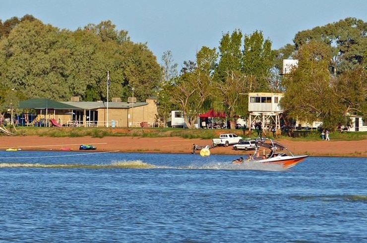 A speedboat tows two skiers o a lake.