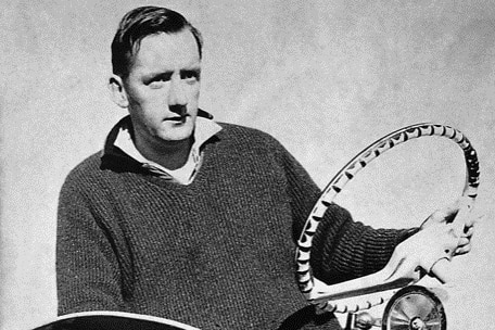 A young Tim Fischer sits on a tractor holding the steering wheel.