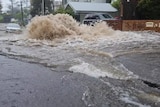 A large amount of water washing down a street 