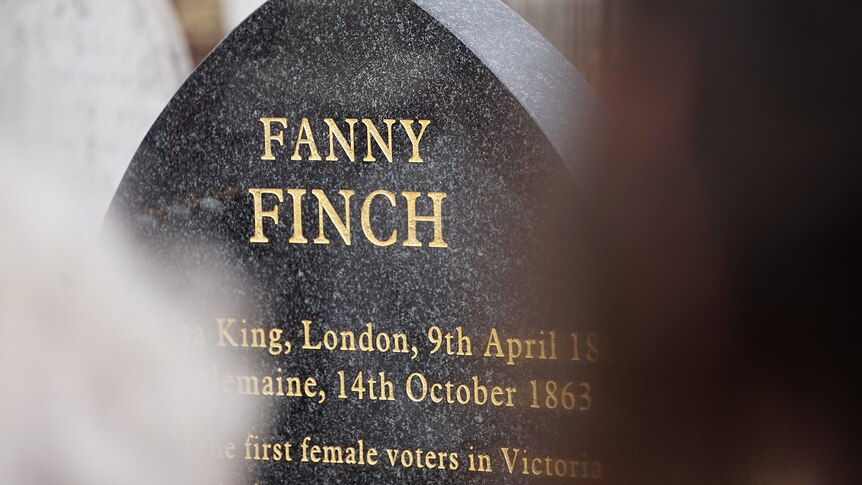 A dark headstone with the name Frances Finch inscribed on it in gold lettering.
